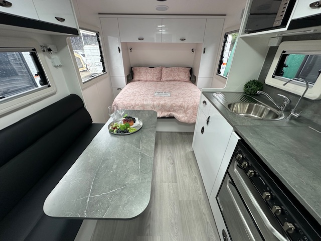 Kitchenette, dining table and bed in the 2024 Viscount V1 caravan